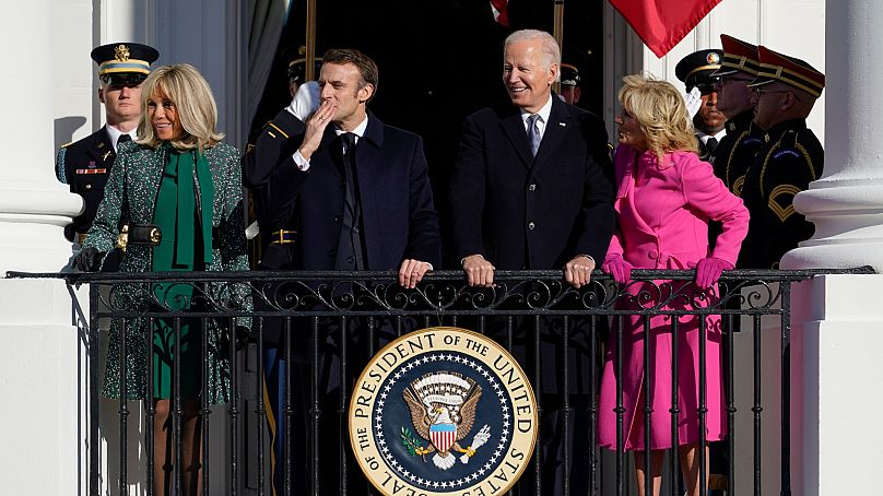Emmanuel Macron przesyła buziaka, stojąc obok swojej żony Brigitte Macron, prezydenta Joe Bidena i pierwszej damy Jill Biden