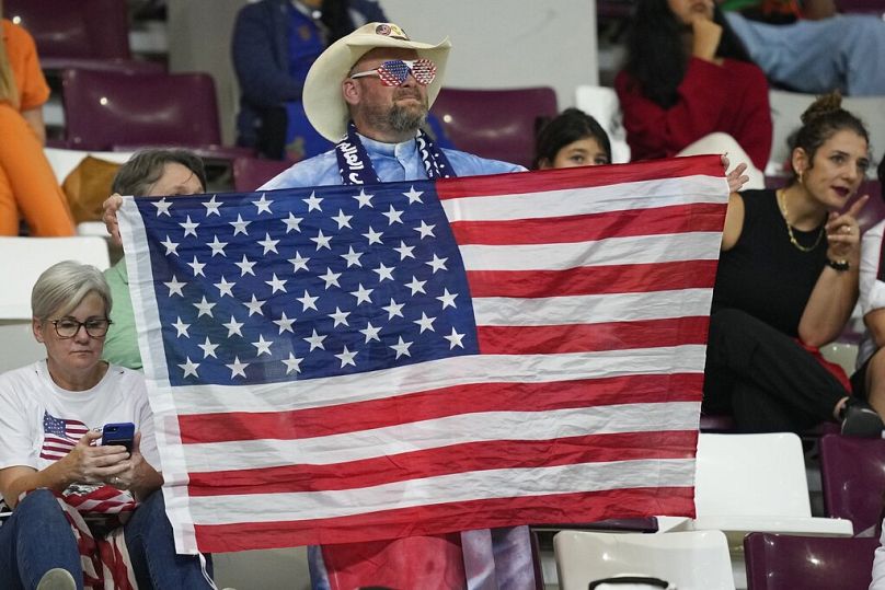 Amerykański kibic trzyma flagę swojego kraju przed rozpoczęciem meczu Pucharu Świata pomiędzy Holandią a USA w Doha, grudzień 2022 r.