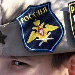 A boy wears Russian insignia on his hat, 12 March 2022