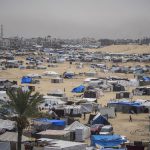 Palestinians displaced by the Israeli air and ground offensive on the Gaza Strip walk through a makeshift tent camp in Rafah, May 10, 2024