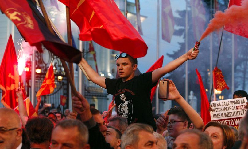 Ludzie demonstrują podczas protestu zorganizowanego przez VMRO-DPMNE przed budynkiem rządowym w Skopje, czerwiec 2018 r.