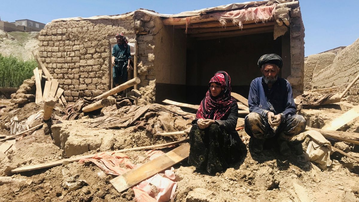 An Afghan couple sit near to their damaged home after heavy flooding in Ghor province in western Afghanistan Saturday, May 18, 2024.