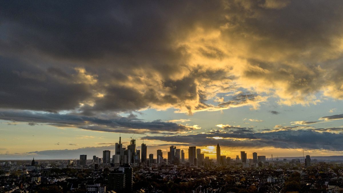 The sun sets behind the skyline as clouds drift by in Frankfurt, Germany, Tuesday, Nov. 7, 2023