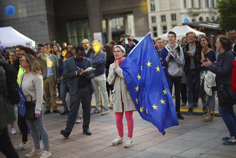 Kobieta trzyma flagę UE podczas festiwalu przed Parlamentem Europejskim w Brukseli, maj 2019 r