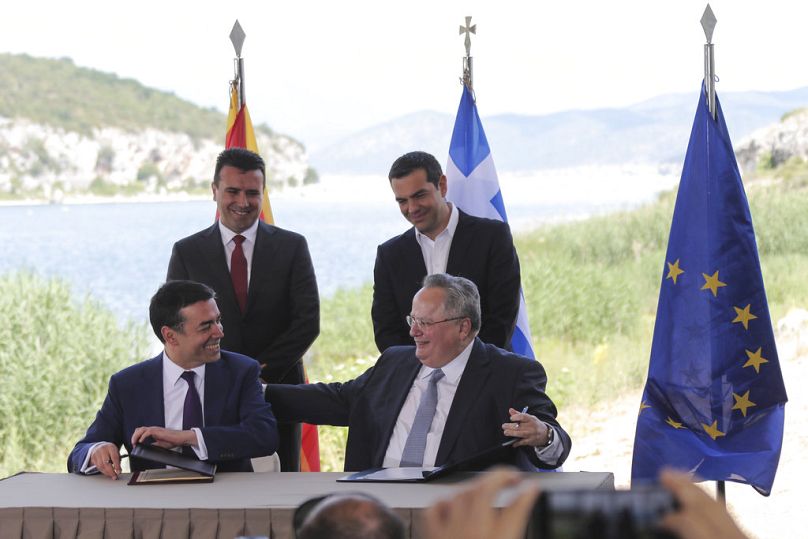 Premierzy Grecji i Macedonii Zoran Zaew i Alexis Tsipras przyglądają się, jak ministrowie spraw zagranicznych Nikos Kotzias i Nikola Dimitrow podpisują porozumienie z Prespy, 17 czerwca 2018 r.