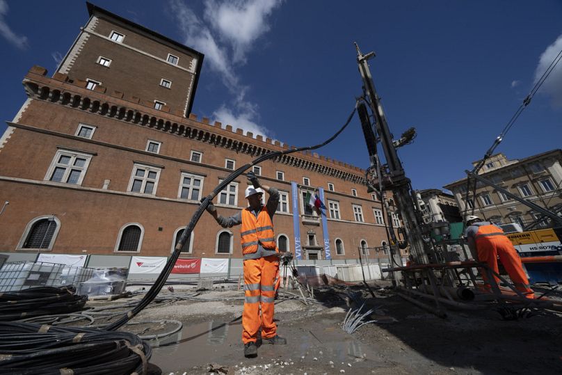 Pracownicy wstrzykują reaktywne chemikalia, aby zagęścić plac budowy na Piazza Venezia w centrum Rzymu, 23 maja 2024 r.