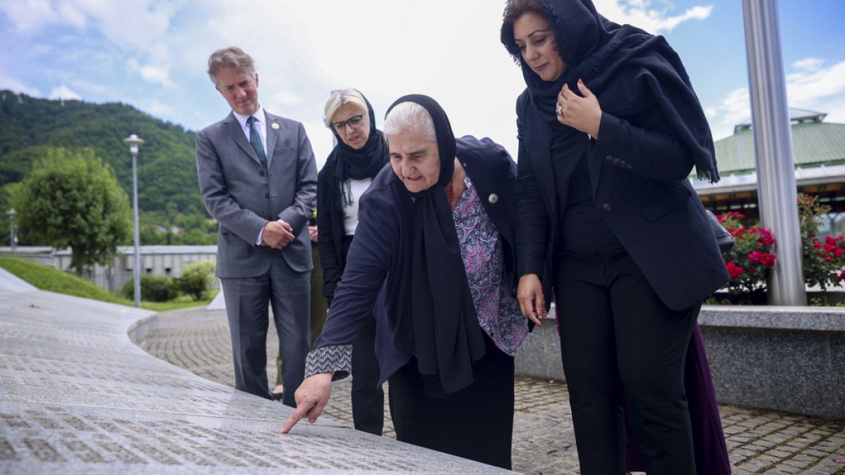 Nusrat Ghani walks with  Munira Subasic next to the momument with the names of Srebrenica genocide victims in Potocari, Bosnia, Wednesday, May 22, 2024.