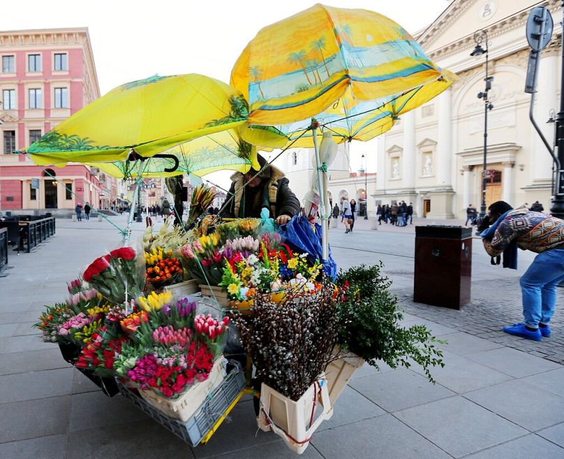 PLIK – Sprzedawca uliczny ciągnie rower sprzedający kwiaty na Starym Mieście w Wielkanoc w Warszawie, Polska, niedziela, 27 marca 2016 r.