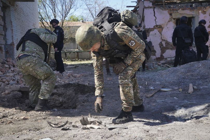 Policjant bada fragmenty bomby kierowanej po rosyjskim nalocie na Charków na Ukrainie, wtorek, 30 kwietnia 2024 r.