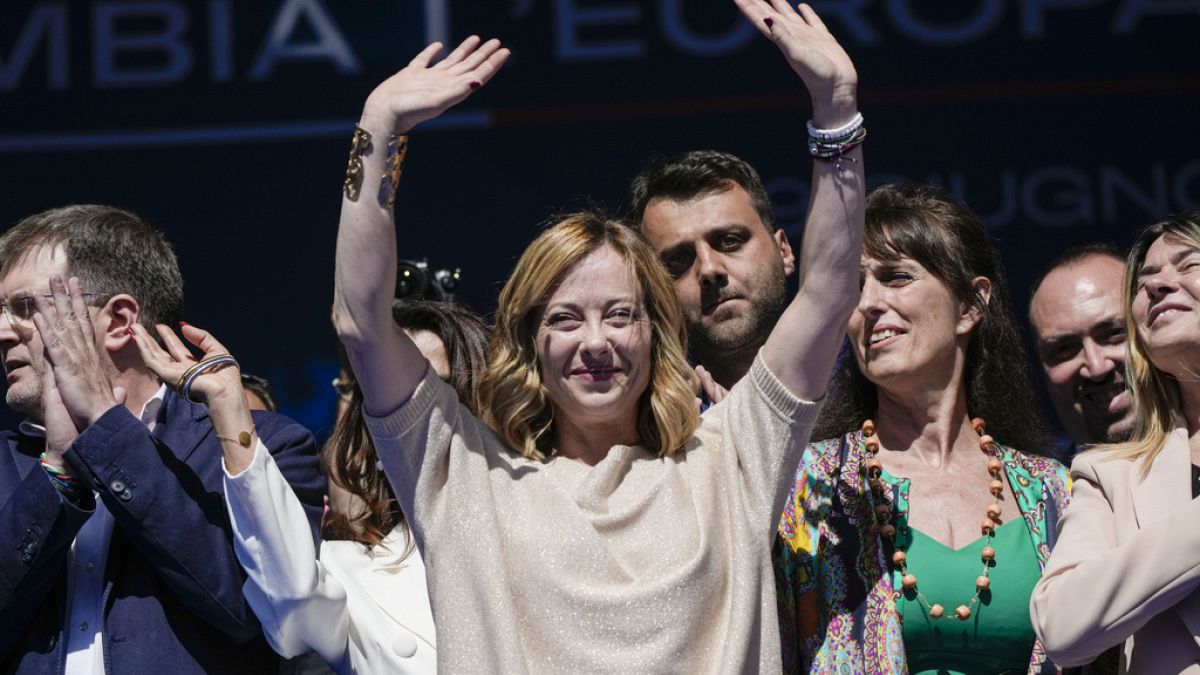 Giorgia Meloni and Brothers of Italy fellow party members wave during an electoral rally ahead of the EU parliamentary elections, June 1, 2024.