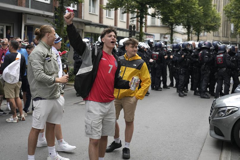 Angielscy kibice piłki nożnej kibicują przed policją przed meczem grupy C pomiędzy Serbią a Anglią podczas Euro 2024 w Gelsenkirchen w Niemczech, niedziela, 16 czerwca 2024 r.