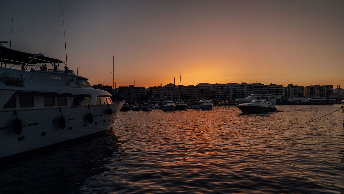 Boats off Ibiza, Spain, during golden hour.