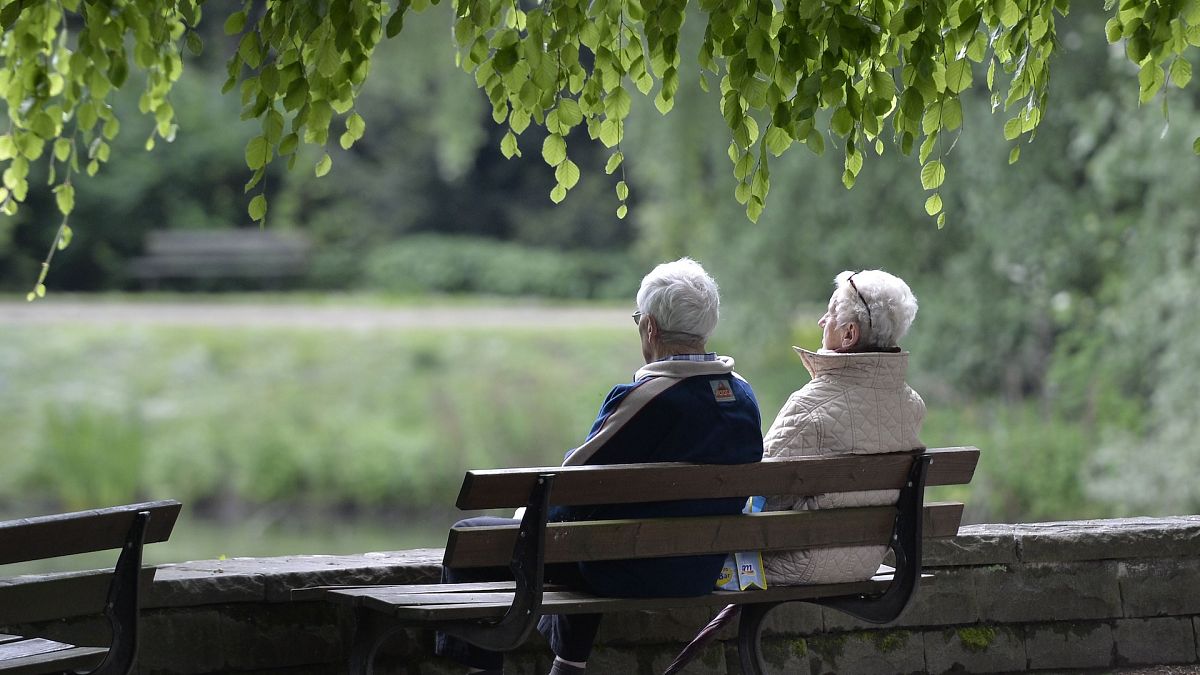 An elderly couple sits on a bench in a park in Gelsenkirchen, Germany.