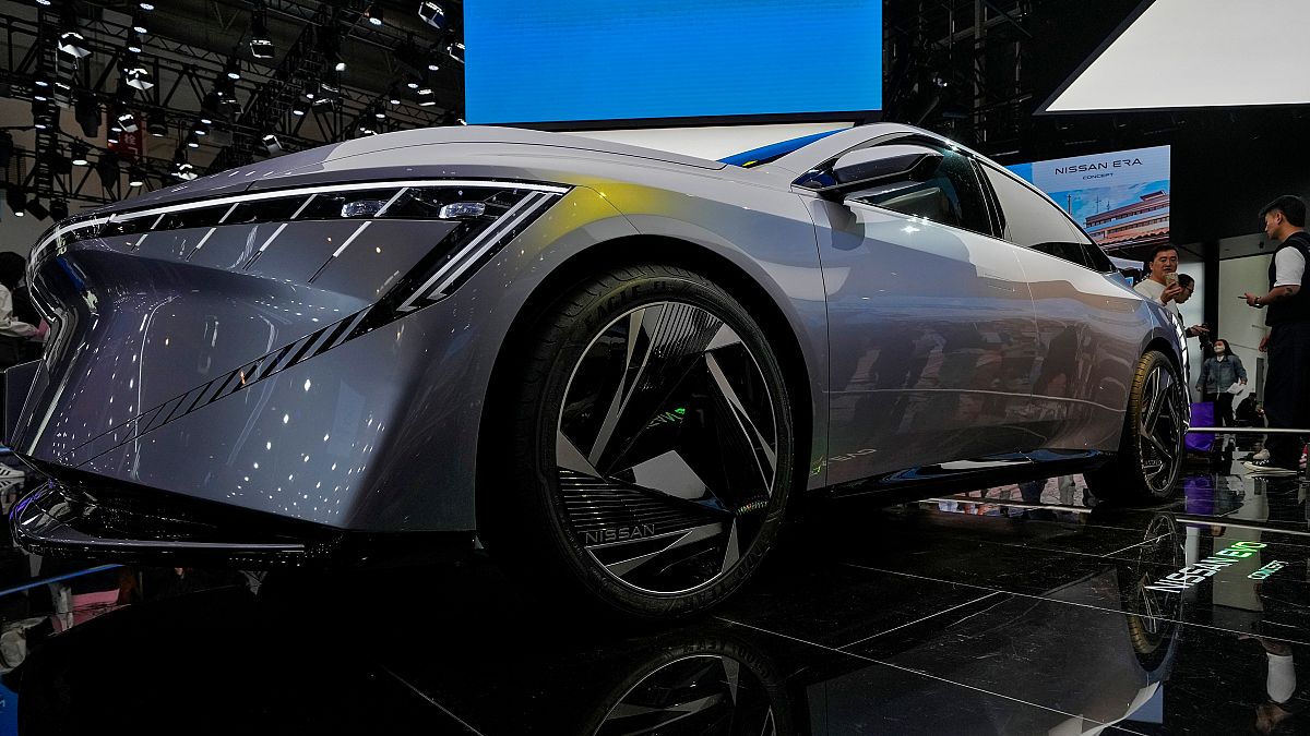 A visitor takes a photo of a Nissan EVO Concept car model on display during the Auto China 2024 in Beijing, Sunday, April 28, 2024.