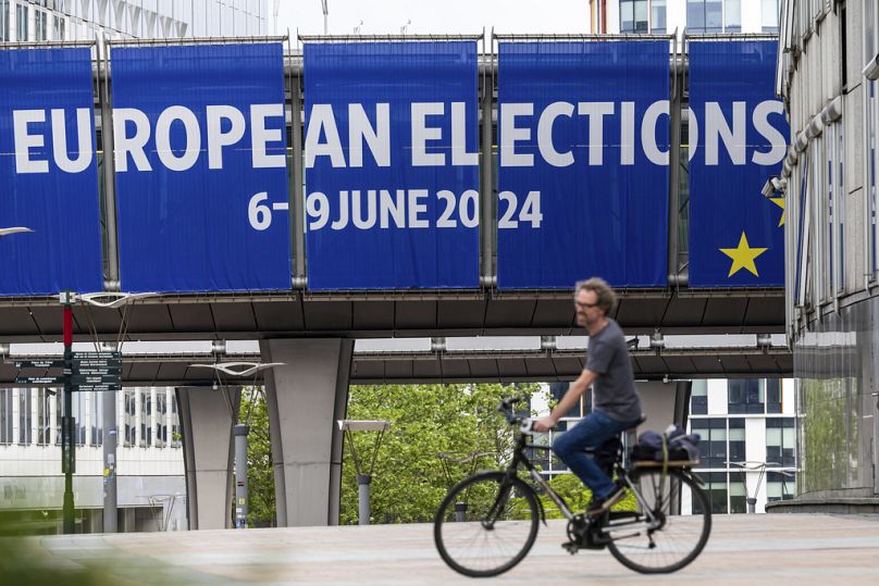 Mężczyzna jedzie na rowerze przed Parlamentem Europejskim, maj 2024 r