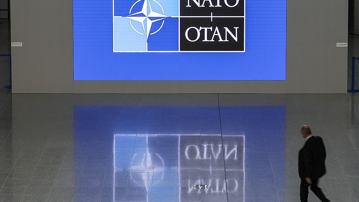 A man walks in the lobby of the NATO headquarters, Wednesday, Nov. 16, 2022 in Brussels.