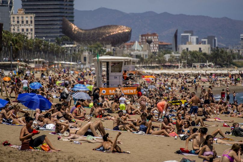 Ludzie opalają się na plaży w Barcelonie, Hiszpania.