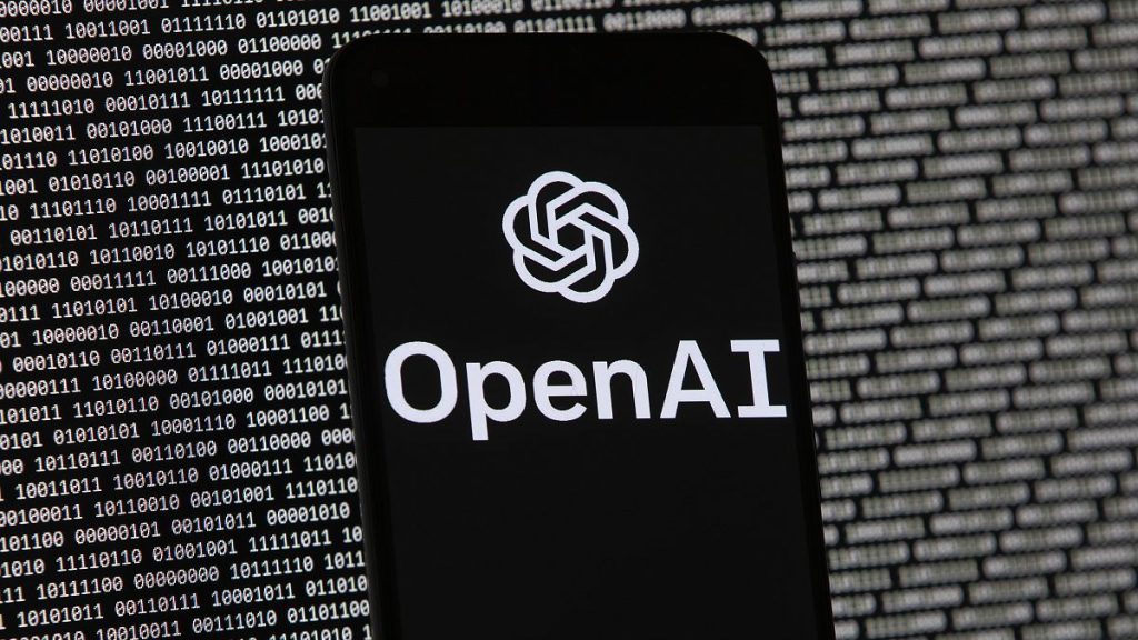 The OpenAI logo appears on a mobile phone in front of a computer screen with random binary data, Thursday, March 9, 2023, in Boston.