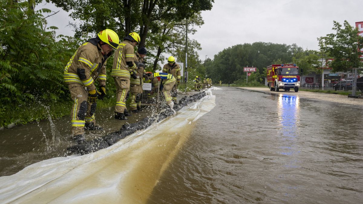 Firefighters work on a street flooded by the Günz in Ichenhausen, Germany, Saturday, June 1, 2024.  (Stefan Puchner/dpa via AP)