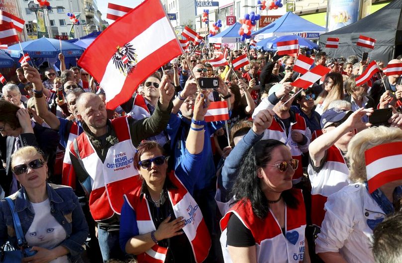 Zwolennicy machają austriackimi flagami podczas ostatniego wydarzenia kampanii wyborczej prawicowej Partii Wolności (FPOE) przed wyborami europejskimi w Wiedniu, piątek, 24 maja 2024 r.