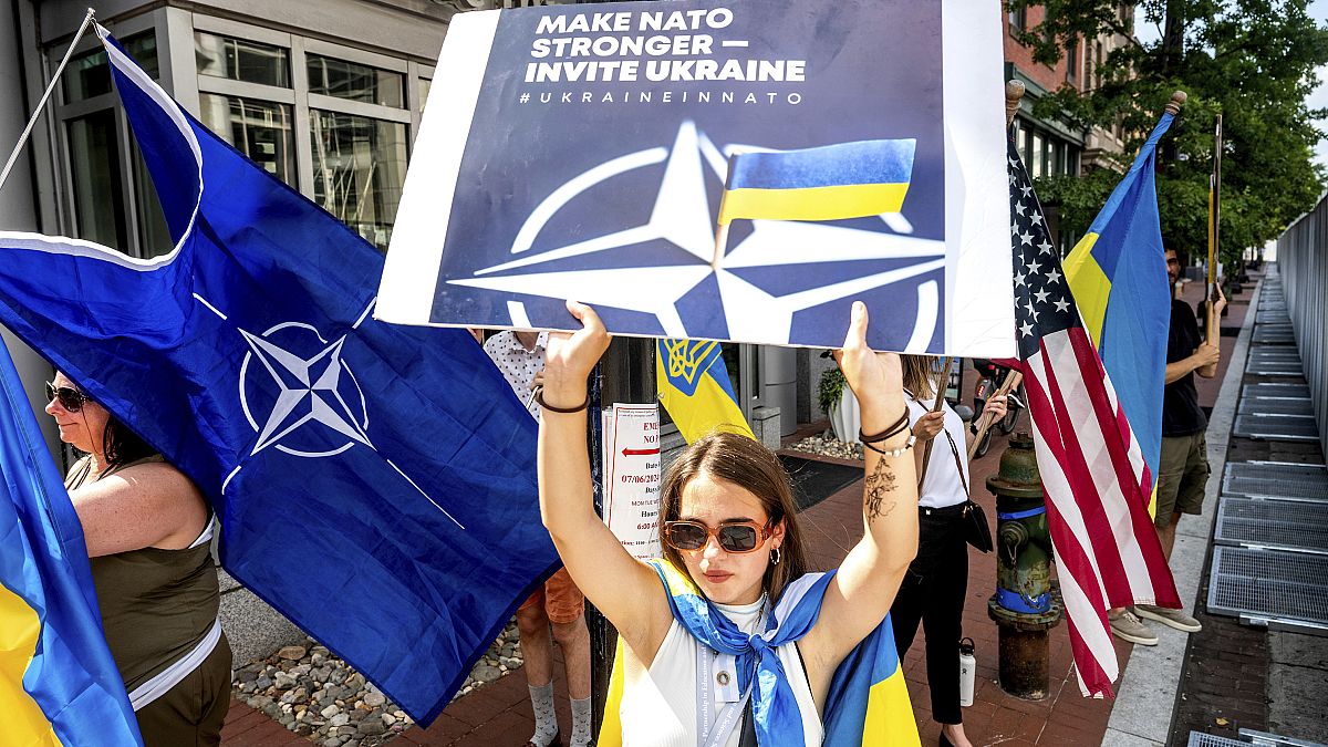 Ukrainian refugee Mariia Hlyten holds a sign outside the NATO summit in Washington.