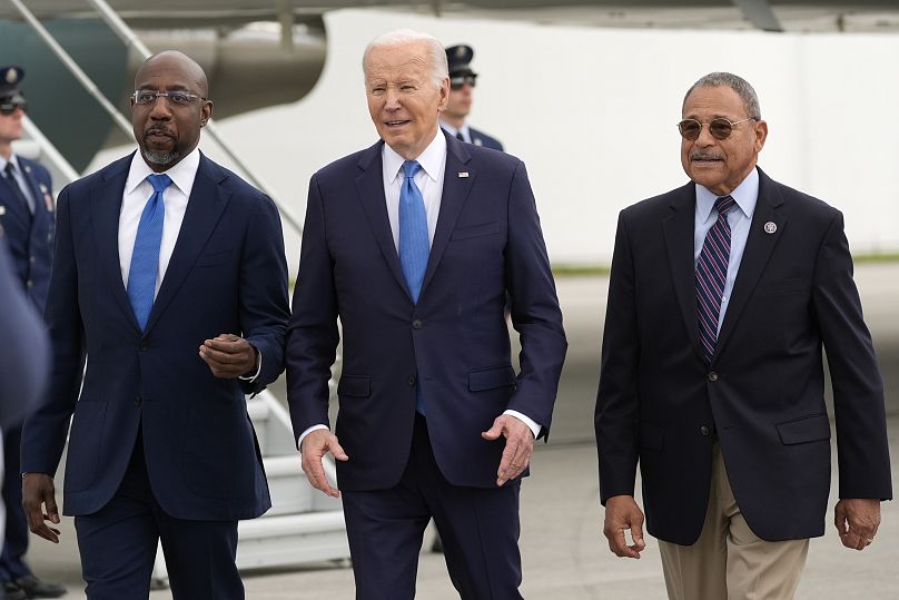 Prezydent Joe Biden spaceruje z senatorem Raphaelem Warnockiem i przedstawicielem Sanfordem Bishopem po przybyciu na międzynarodowe lotnisko Hartsfield-Jackson w Atlancie.