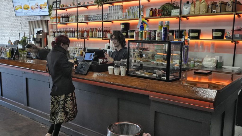 A customer buys a cup of coffee at the Blind Tiger Cafe on Jan. 10, 2024, in Tampa, Fla.