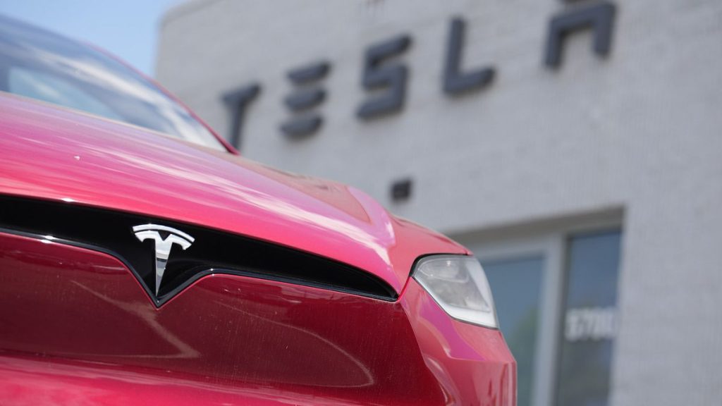 A Tesla model X sports-utility vehicle sits outside a Tesla store.