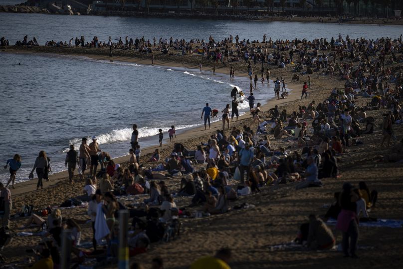   Ludzie opalają się na plaży w Barcelonie, Hiszpania, niedziela, 12 marca 2023 r.