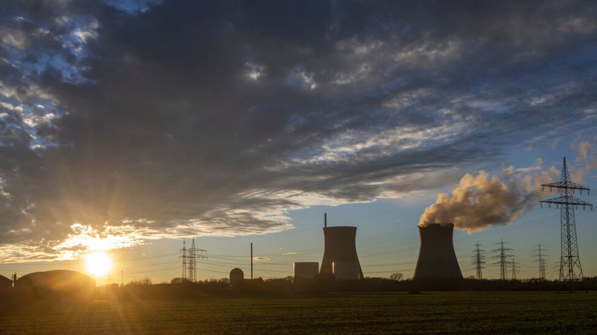 Steam rises from the cooling tower of the nuclear power plant of Gundremmingen, Bavaria, Germany, Friday, December 31, 2021.