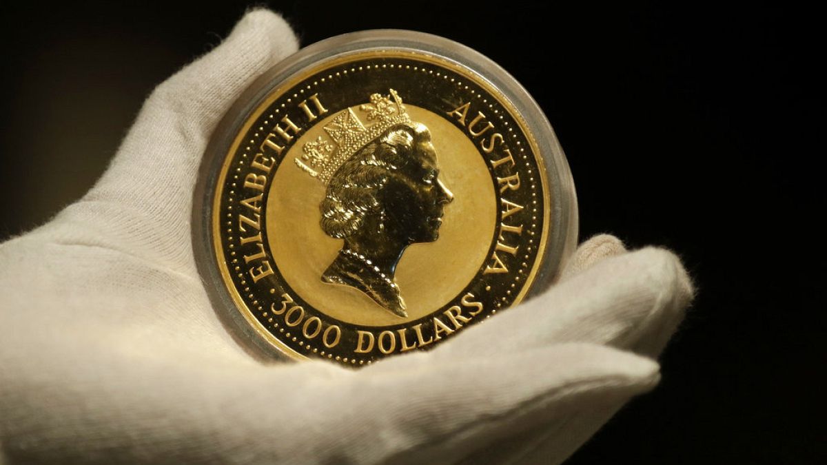 An employee of ProAurum gold house presents the Australian 1 Kg Gold Coin - 999.9 purity in the safe deposit boxes room in Munich, Germany, Thursday, Dec. 13, 2018. (AP Photo/