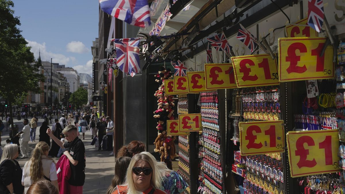 People walk along a street in a shopping district in central London