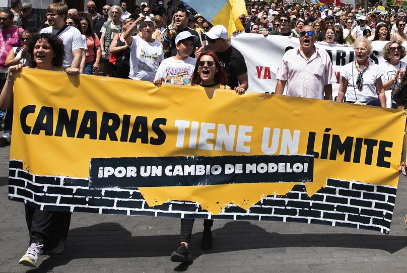 Ludzie maszerują podczas masowej demonstracji przeciwko turystyce, która dotyka miejscową ludność, uniemożliwiając dostęp do mieszkań i nie tylko w Santa Cruz de Tenerife