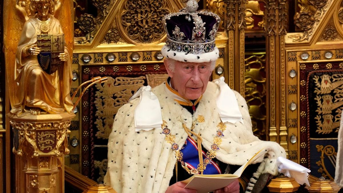 King Charles III looks up as he reads the King