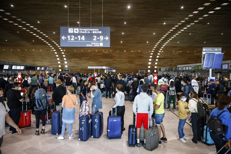 Pasażerowie czekają na odprawę w terminalu lotniska Charles de Gaulle.