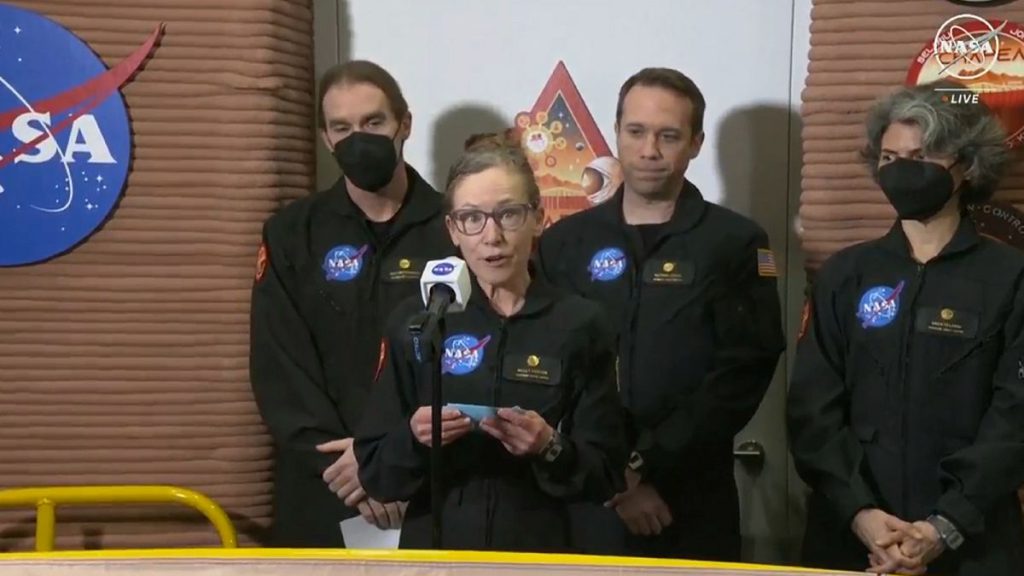 Kelly Haston, a crew member of the first CHAPEA mission, speaks in front of other members  at Johnson Space Center in Houston, Texas.