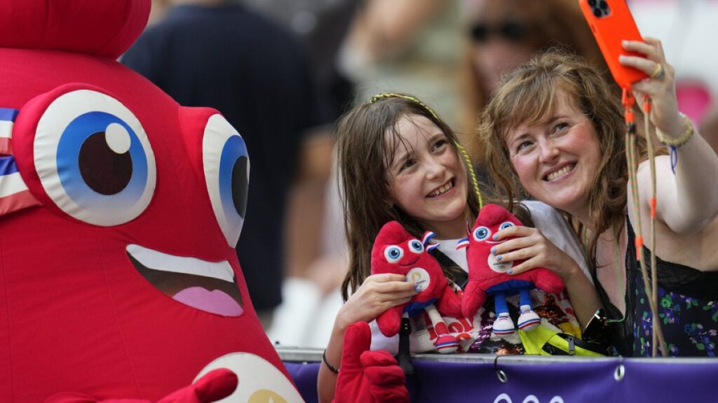 Phryge, the mascot of the Paris 2024 Olympic Games poses for a selfie with fans at the 2024 Summer Olympics, Sunday, July 28, 2024, in Nice, France.