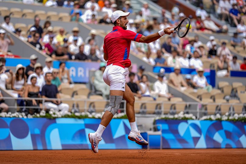 Serbski Novak Djokovic odbija piłkę w kierunku Niemca Dominika Koepfera podczas męskiego turnieju singlowego na stadionie Rolanda Garrosa