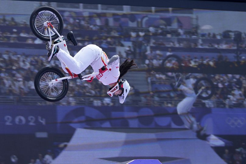 Deng Yawen z Chin wykonuje sztuczkę przed ekranem wideo podczas finału jazdy na rowerze BMX freestyle kobiet w parku podczas Letnich Igrzysk Olimpijskich 2024, środa, 31 lipca 2024 r.