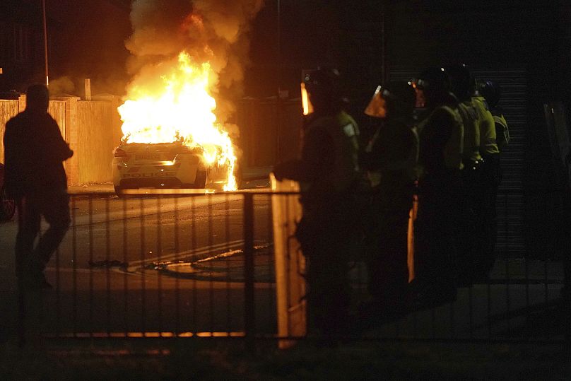 Samochód policyjny płonie, gdy funkcjonariusze są rozmieszczani na ulicach Hartlepool w Anglii po gwałtownym proteście po zabójstwie trzech dziewcząt