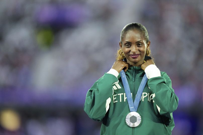 Srebrna medalistka w maratonie kobiet Tigst Assefa z Etiopii stoi na podium podczas ceremonii zamknięcia Letnich Igrzysk Olimpijskich 2024 na Stade de France