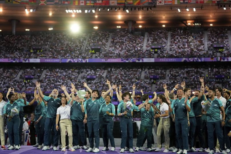 Wolontariusze machają podczas ceremonii zamknięcia Letnich Igrzysk Olimpijskich 2024 na Stade de France, niedziela, 11 sierpnia 2024 r., w Saint-Denis we Francji