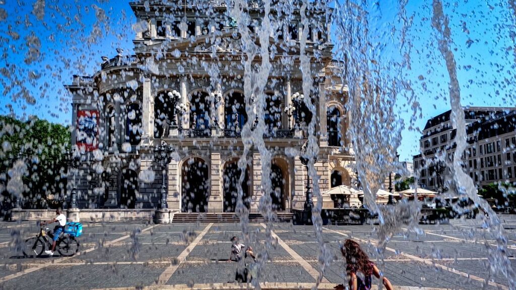 Water runs down from a fountain in front of the Old Opera in Frankfurt, Germany.