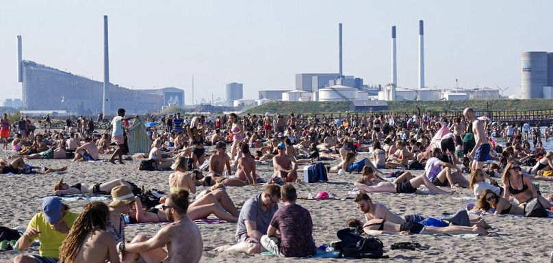 Ludzie udają się na plażę w Kopenhadze w Danii w upalny letni dzień z temperaturami przekraczającymi 30 stopni Celsjusza, piątek, 18 czerwca 2021 r. 