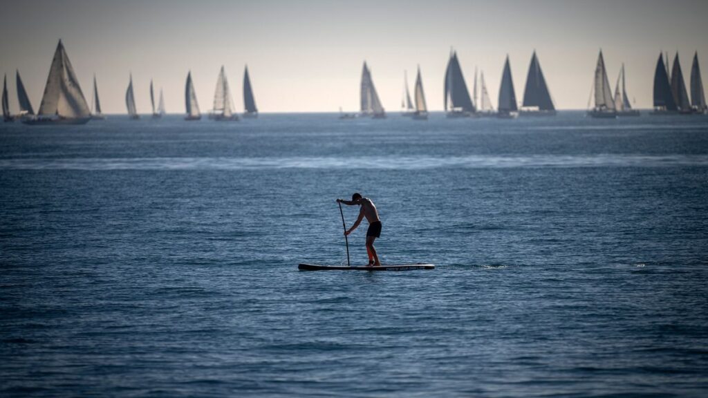 A man paddles in the Mediterranean Sea in Barcelona, Spain.