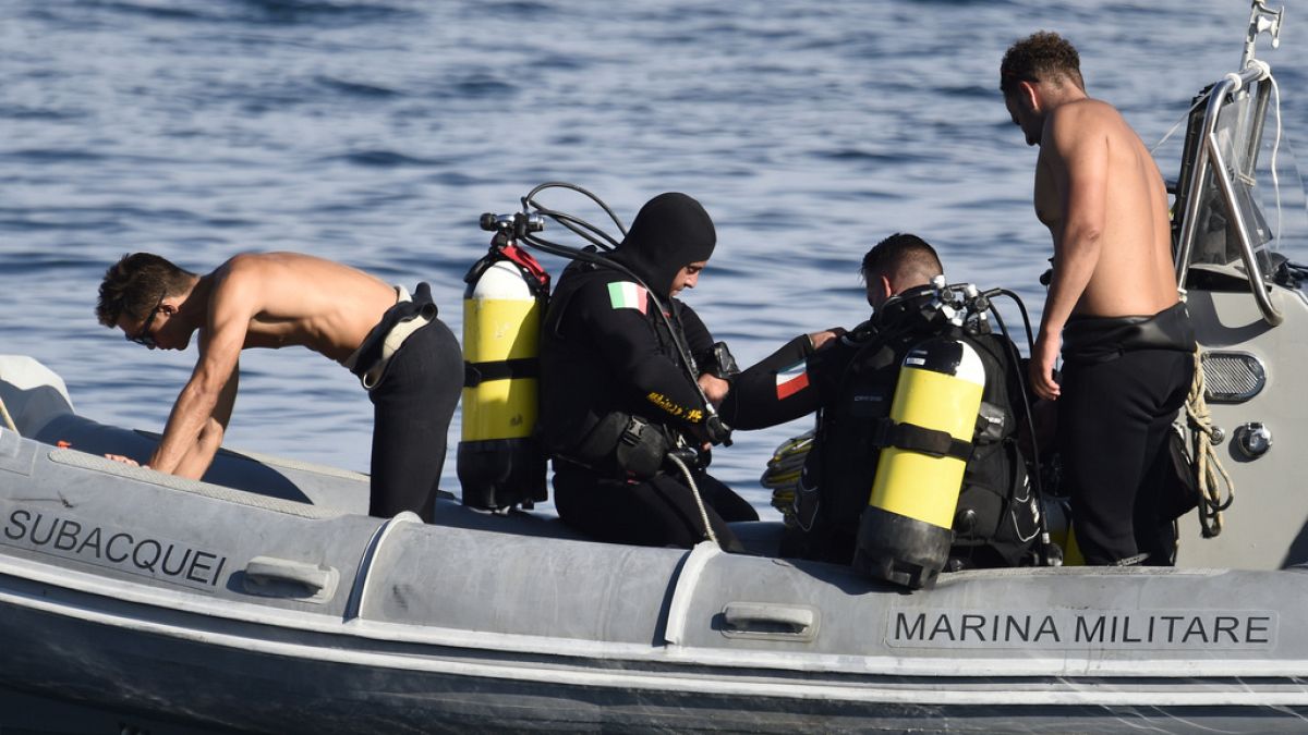 Italian firefighter divers bring ashore in a plastic bag the body of one of the victims of a shipwreck, in Porticello, Sicily, southern Italy, Thursday, Aug. 22, 2024.