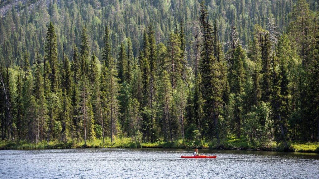 A paddler on Lake Kesanki in Akaslompolo, Kolari, Lapland, Northern Finland, July 2021, during a heatwave.