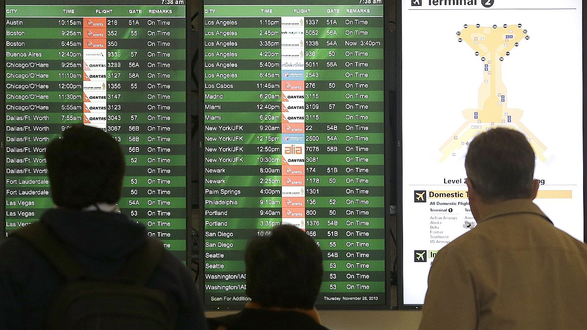 A group looks at the departures board in the domestic terminal at San Francisco International Airport in San Francisco, Thursday, Nov. 28, 2013.