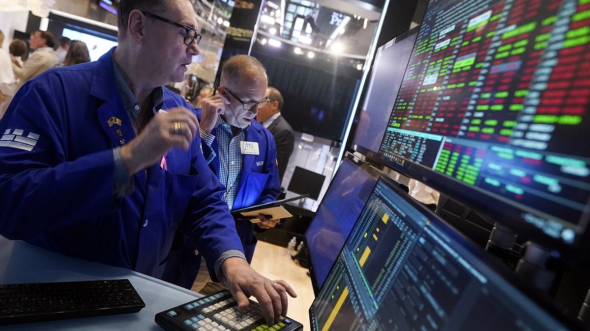 Specialist Patrick King, left, works at his post on the floor of the New York Stock Exchange, Tuesday, Aug. 6, 2024.