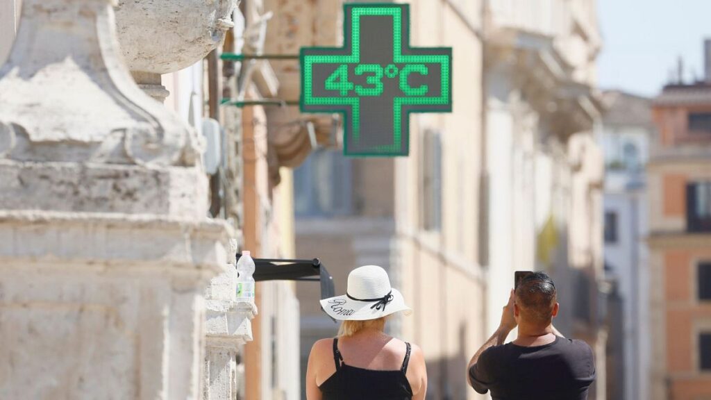 A man takes a photo of the temperature of 43 degrees C recorded in the sun outside a pharmacy in Rome, 11 July 2024.